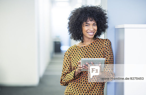 Portrait of woman using digital tablet in office