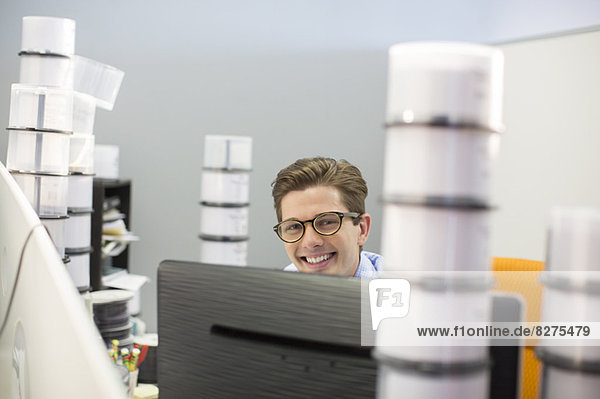 Porträt eines lächelnden Geschäftsmannes umgeben von CD-Hüllen