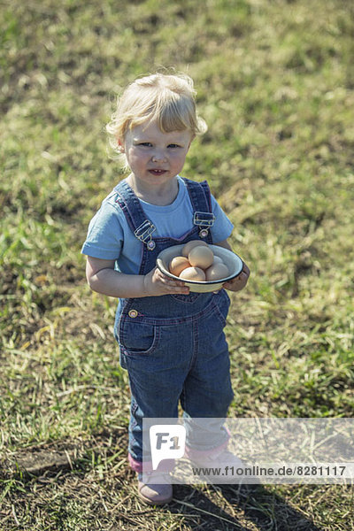 Farmer girl holding bowl of eggs