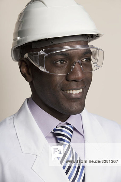 Laboratory worker wearing hard hat  protective goggles and lab coat