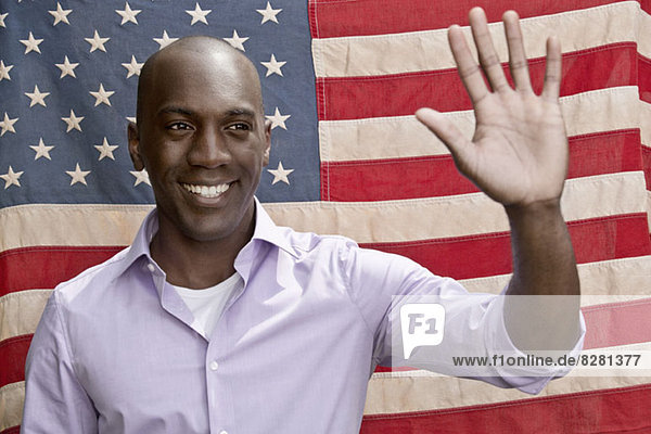 Elected politician waving in front of American flag