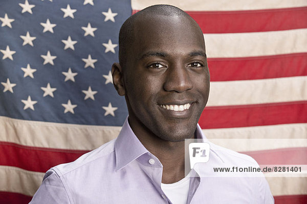 Smiling man in front of American flag