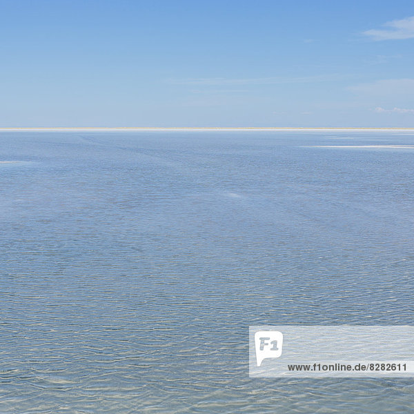 The View Across The Flooded Bonneville Salt Flats  At Dusk. Flat Landscape. A White Line Marking The Horizon.