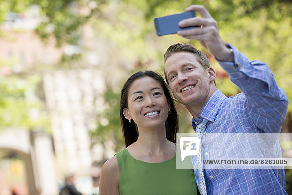 Ein Paar  ein Mann und eine Frau  die sich mit einem Smartphone selbstständig machen.