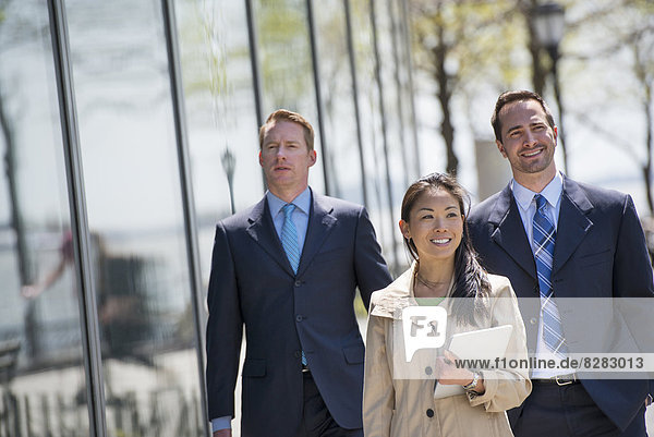 A Businesswoman And Two Businessmen Outdoors In The City.