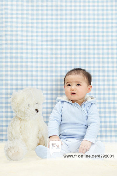 Baby boy sitting with soft toy