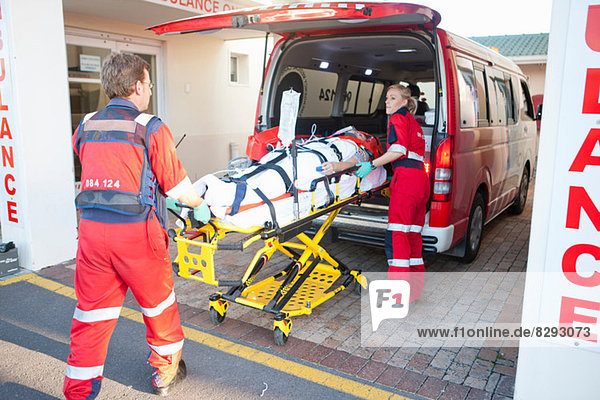 Rettungssanitäter beim Anheben des Patienten aus dem Krankenwagen