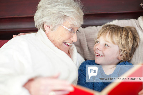 Großmutter und Enkel lesen im Bett