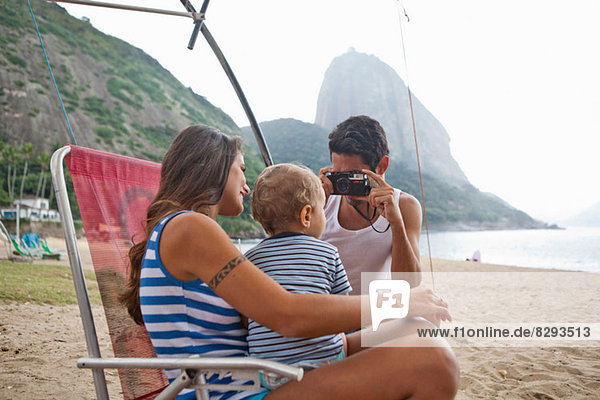 Man taking photograph of mother and son on chair  Rio de Janeiro  Brazil