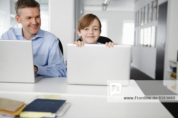 Vater und Sohn mit Laptops