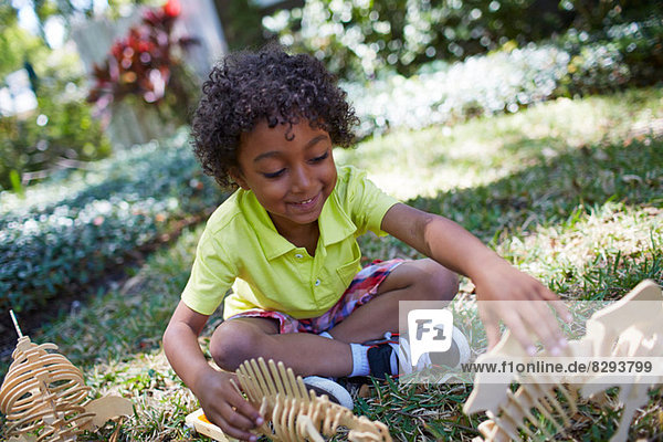 Junge spielt mit Dinosaurier-Skelett-Spielzeug