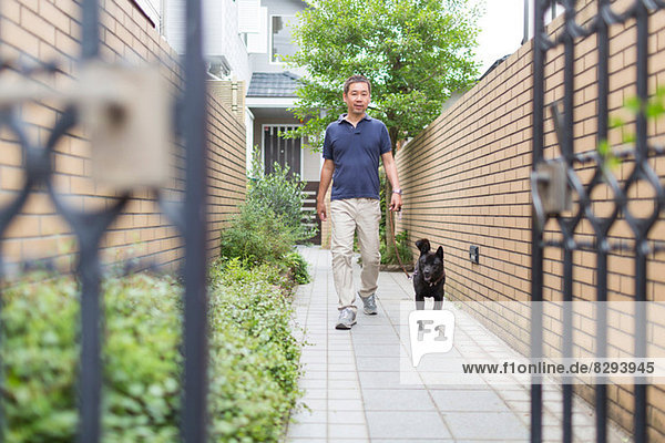 Mann geht mit seinem Hund spazieren