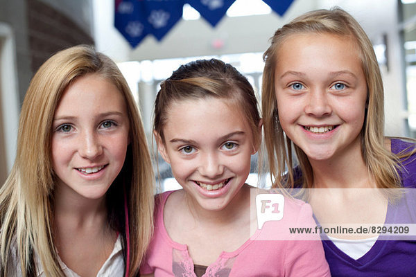 Nahaufnahme von drei lächelnden Teenagern und vorpubertären Mädchen
