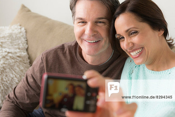 Mature couple photographing themselves with digital camera