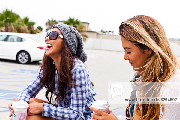 Female friends sitting in car lot  Hermosa Beach  California  USA