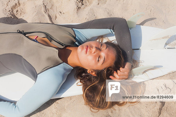 Junge Frau beim Sonnenbaden auf dem Surfbrett  Hermosa Beach  Kalifornien  USA