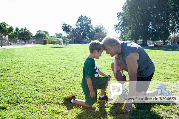 Junge und Großvater Kopf an Kopf  Mann mit Fußball