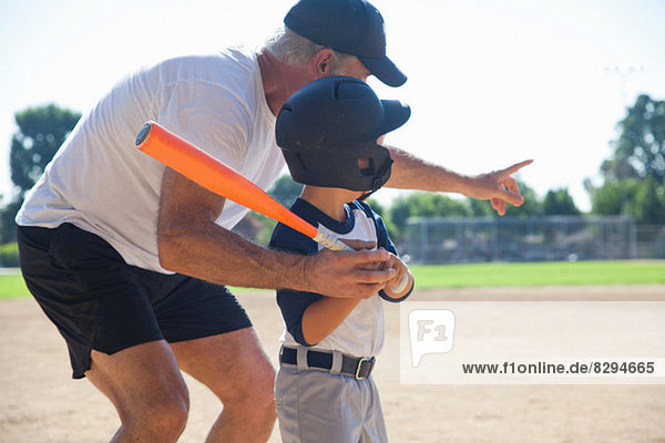 Mann lehrt Enkel Baseball spielen