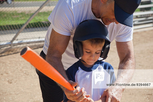 Mann lehrt Enkel Baseball spielen