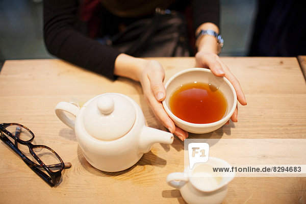 Frau hält Tasse Tee  hoher Winkel