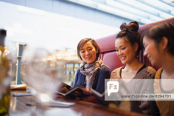 Junge Frauen lesen Menüs im Café