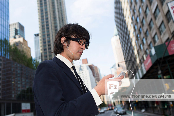 Young businessman using mp3 player