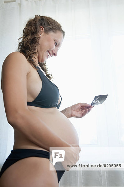 junge schwangere Frau mit Sonogramm