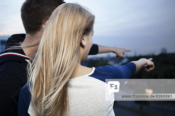 Junges Paar im Morgengrauen auf dem Flachdach