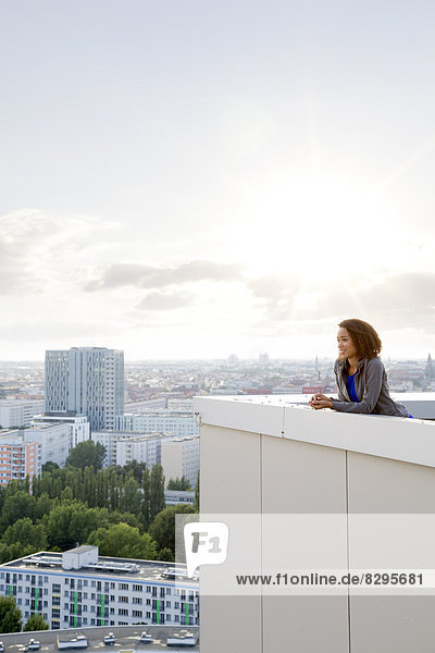 Young woman on rooftop terrace  looking at view