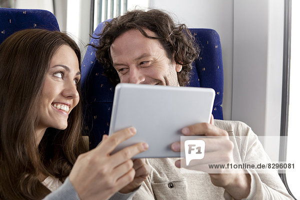 Paar mit digitalem Tablett in einem Zug