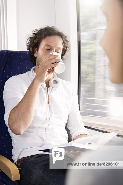 Man drinking coffee in a train