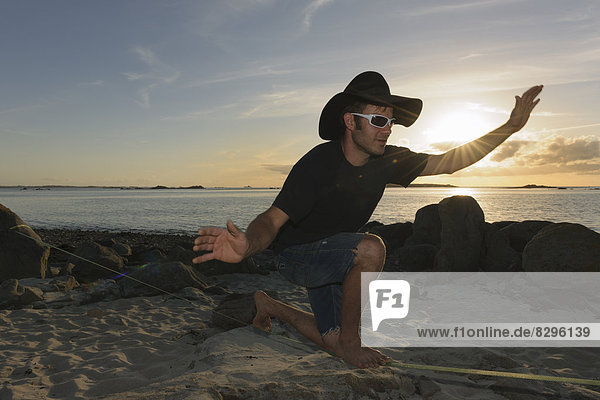 France  Bretagne  Landeda  Man balancing on slackline on beach