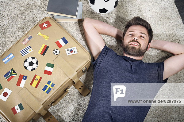Fußballfan mit Nationalflaggen auf dem Koffer