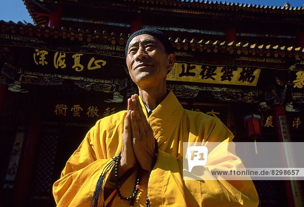 Farbaufnahme  Farbe  Zusammenhalt  Nachthemd  Gebet  fünfstöckig  Buddhismus  Safran  China  Mönch