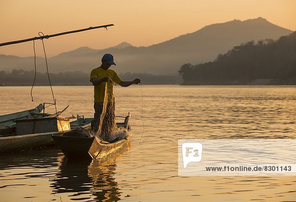 Man reeling in fishing net on Mekong River  Luang Prabang  Laos  Indochina  Southeast Asia  Asia