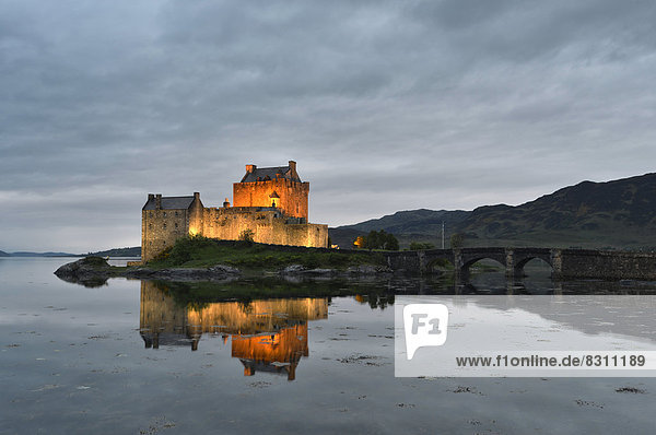 Eilean Donan Castle  ancestral seat of the Scottish clan of Macrae  reflected in Loch Duich in the evening