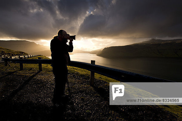 Silhouette of a photographer standing in front of dramatic  atmospheric clouds
