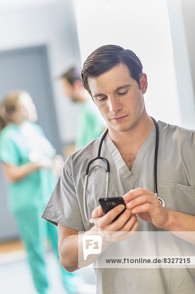 Male doctor texting on phone