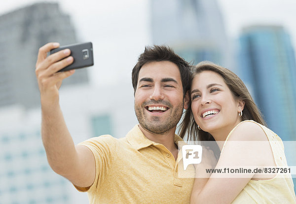 Couple taking self portrait photo with smartphone