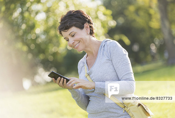 Mature woman text messaging outdoors
