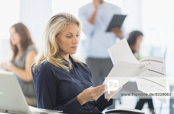 Woman reading at desk in office