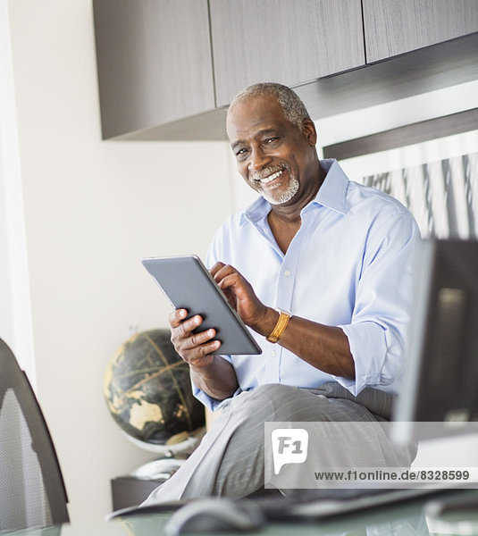 Portrait of senior man using digital tablet in office
