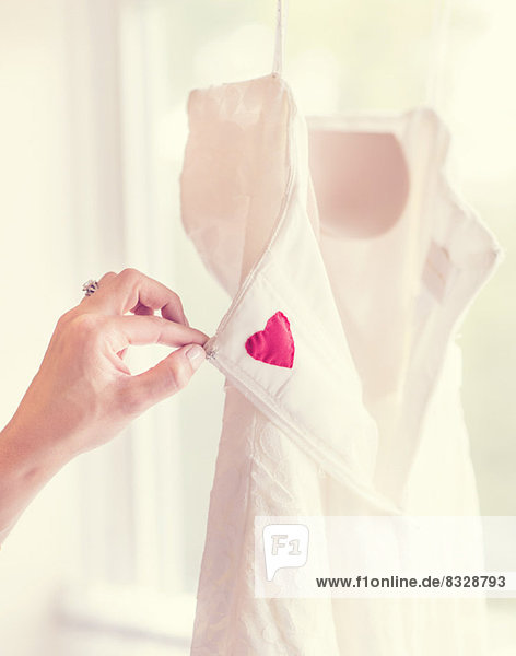 Close up of woman's hand holding wedding dress