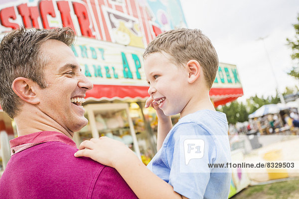 Father and son (4-5) in amusement park