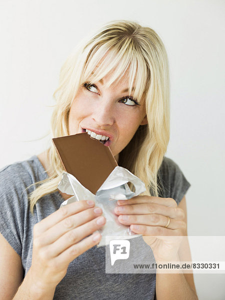 Portrait  Frau  Schokolade  Studioaufnahme  essen  essend  isst  blond