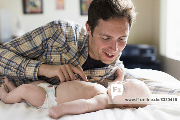 Father playing with baby boy (2-5 months)