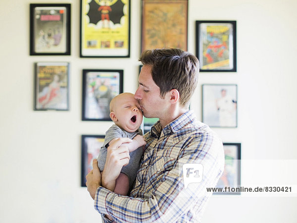 Menschlicher Vater Sohn küssen Baby