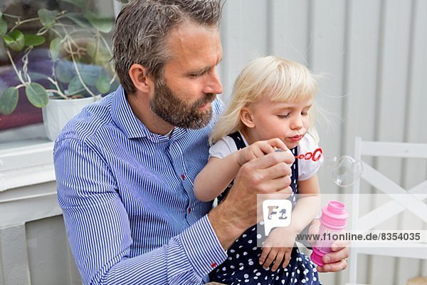 Father with daughter blowing bubbles