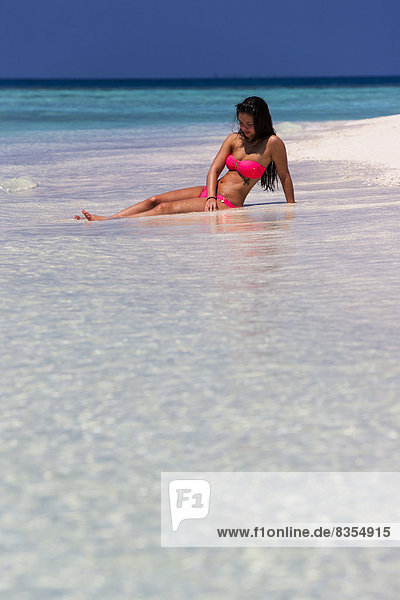 Frau im pinken Bikini liegt am Strand  Malé  Nord-Malé-Atoll  Malediven