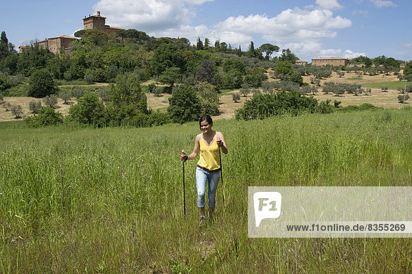 Woman hiking  behind the Palazzo Massani winery  near San Quirico d'Orcia  Tuscany  Italy